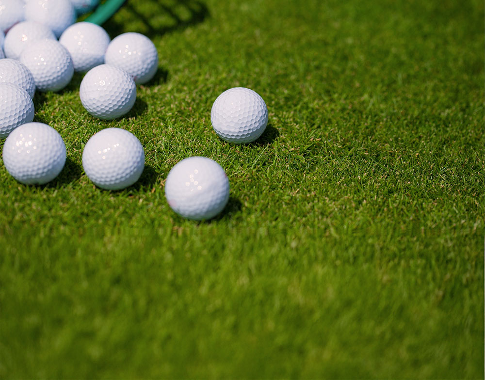 A bunch of golf balls on the grass